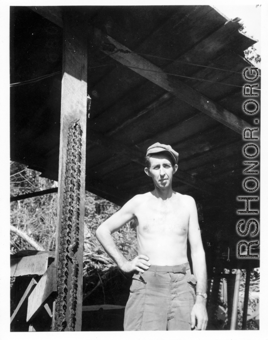 Engineer of the 797th Engineer Forestry Company poses with sharp chain from chainsaw in Burma.  During WWII.