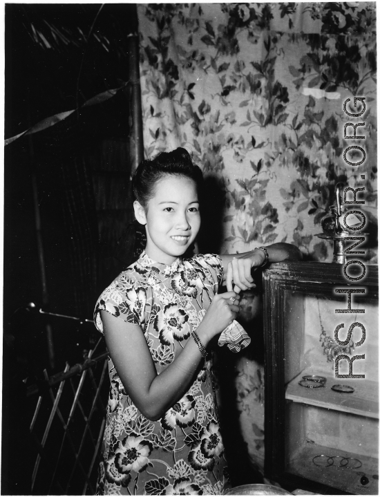 Local people in Burma near the 797th Engineer Forestry Company--a merchant girl in a fine shop in Burma. Given her clothing and economic niche, she is likely to be a member in a Chinese merchant family.  During WWII.