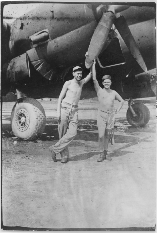 Men of 330th Troop Carrier, 9th CC, stand with C-46 transport.   The writing on the back of this picture indicates the person on the left is Dave Sobel, with Arnold Wall on the right (on different pictures gives a name Milt Sobel. However, Milt Sobel is closer in height to Arnold, and Milt also commonly has a cigarette in his left hand).   From the collection of Arnold Wall. (Much appreciation to son D. W.)