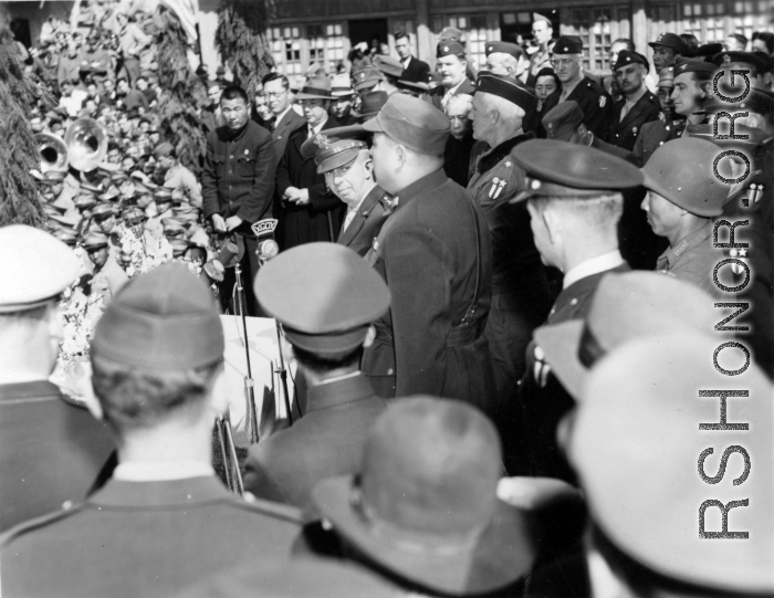 Burma Road dedication parade and ceremony in Kunming, China, on or around February 4, 1945, during WWII. Review of first convoy (or one of the first convoys) to reach China. Chinese and American military officers give speeches into microphones.