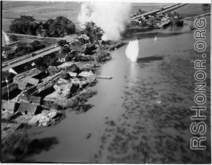 Bombing of small rail bridge, among a flood plain, in French Indochina during WWII.