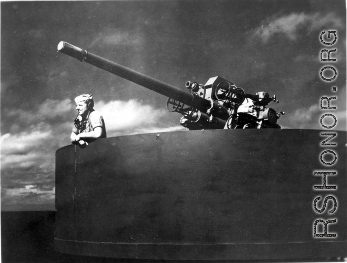 Man with microphone in gun emplacement on transport ship home from CBI to US after WWII.