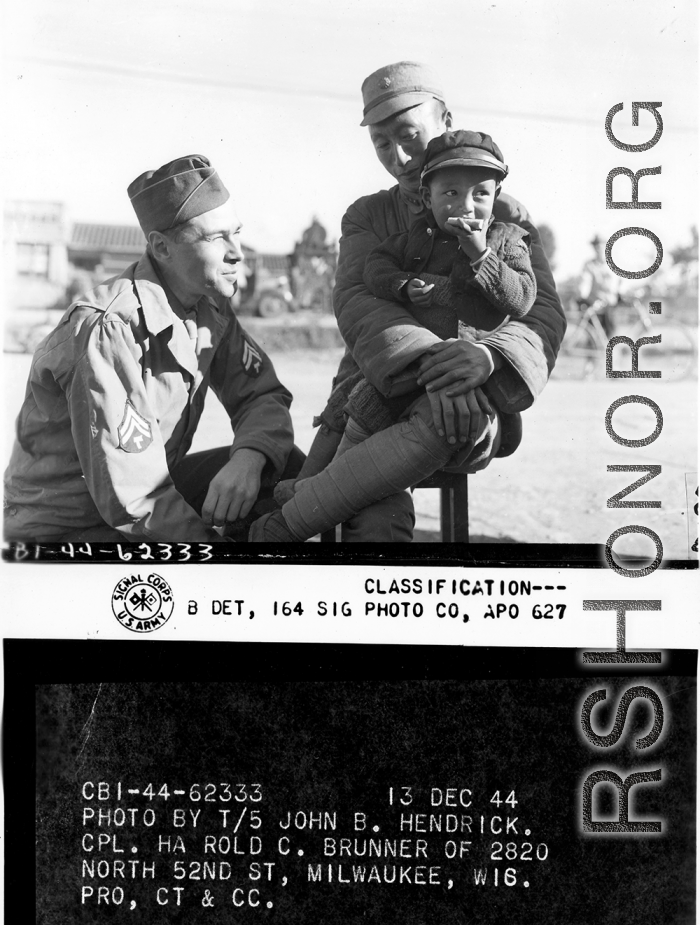 Cpl. Harold C. Brunner interacts with Chinese and child during WWII in China.  Yunnan Province on December 13, 1944.  Photo by T/5 John B. Hendrick.