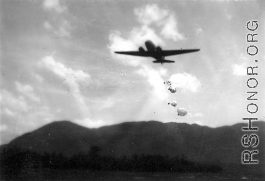 An American transport plane drops supplies by parachute somewhere in the CBI.