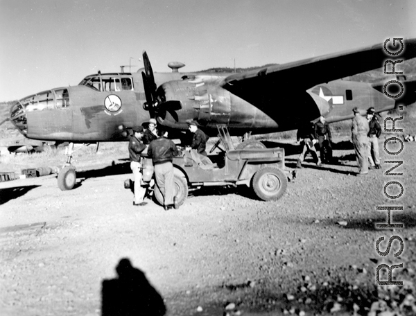 Early morning at Yankai Air Base, China. Aircrew, in flight jackets, and maintenance personnel of the the 491st Bomb Squadron prepare for a mission.  This is probably a newly arrived aircraft, because the B-25D, no mission symbols are displayed below the pilot\'s window.  Photo was probably taken in the spring of 1944.