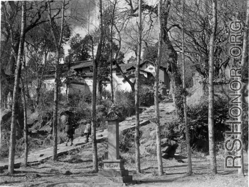 Local people in a village in Yunnan province, China: A walk way up the hill in a small village, with a small commemorative stone erected near by.