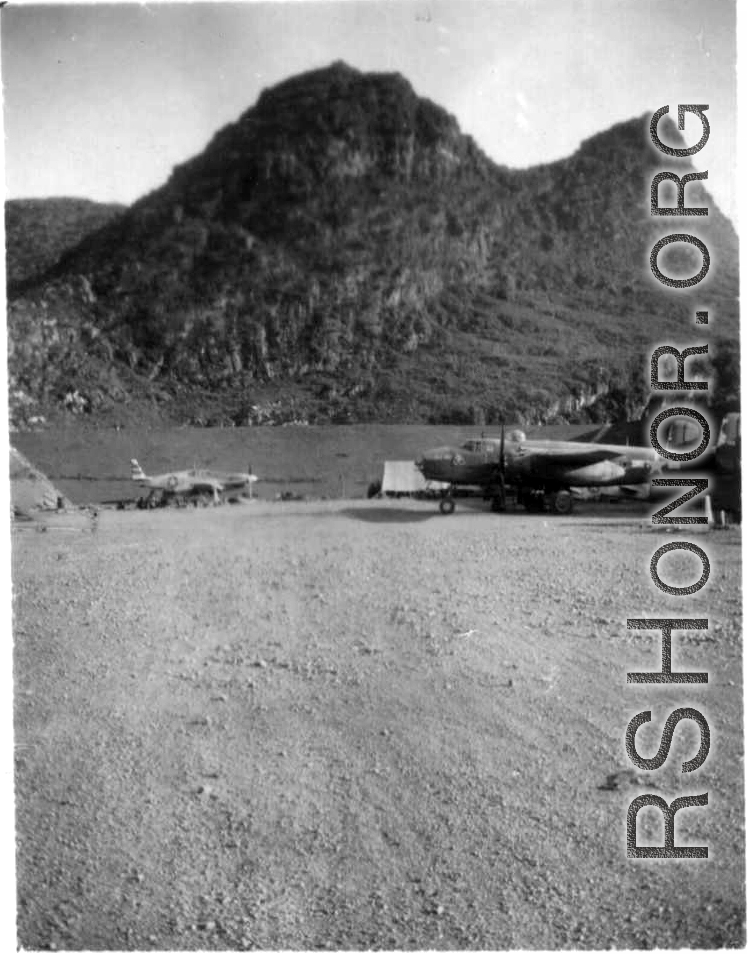 "The Latest In Shops And Equipment--This a picture looking into a revetment that served as our work area and engineering area at Luichow [Liuzhou], China. Lt. Sohl's office was in the little shack at the right and all our tools and equipment was in the tent. We changed a lot of B-24 engines in this revetment along with replacing blown out tires and doing sheet metal repair work. We worked here until the Japanese forced us to evacuate the base and return to Luliang." Caption courtesy of Elmer Bukey.