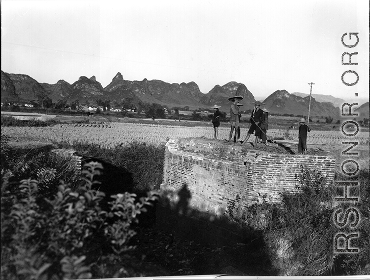 Chinese civilians looking over a bridge destroyed near Liuzhou before the Japanese advance in the fall of 1944.