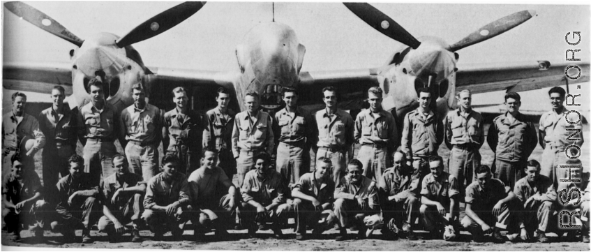 Men from the 21st Photographic Reconnaissance Squadron pose for a group shot in front of an F-5 (a variant of the P-38).