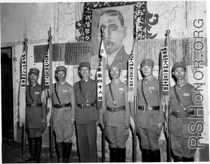 Banner bearers for different regiments of the 48th Army Division stand during rally, with 48th Army Division Zheng Tingji (郑庭笈), commander of the 48th Army Division holding the staff of the division banner. Left of him--the only person not holding a staff--is Chinese Lt. General Du Yuming, commander of Nationalist 5th Corps (第五集团军总司令兼昆明防守司令杜聿明).