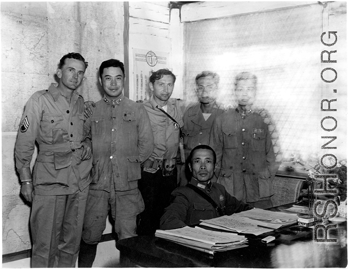 A very emaciated and wary-looking Zheng Tingji (郑庭笈), commander of the 48th Army Division (陆军第四十八师 ), poses at his desk in Yunnan, with GIs and more junior Chinese officers. Eugene T. Wozniak, arms around Chinese comrades, standing in the middle.