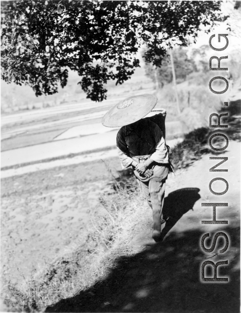 A woman walks in the countryside in Yunnan province, China. During WWII.