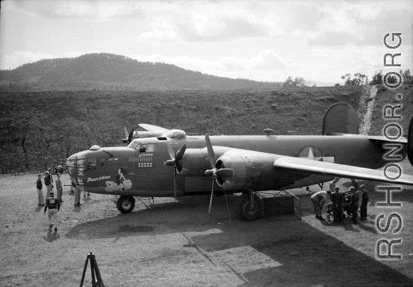 American flyers and mechs gathered around B-24 'Doodlebug' in a revetment in Sichuan, China, likely in preparation for a mission.