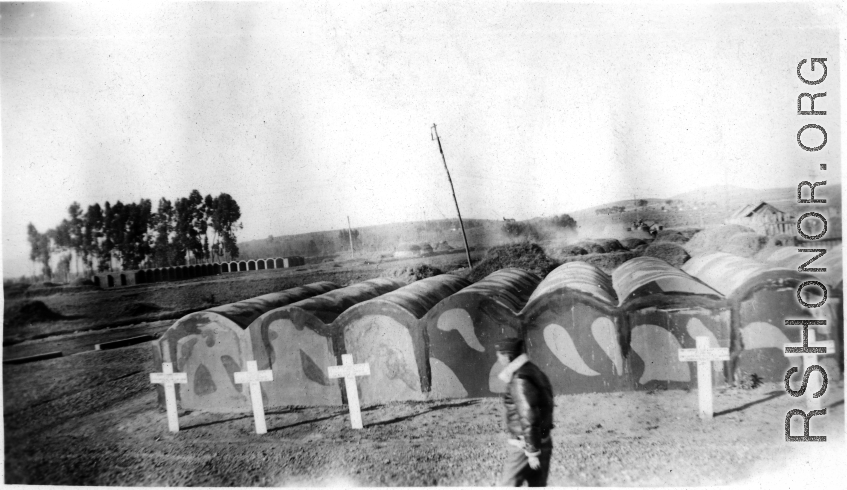 GI walks in front of vaults at an American military graveyard at Kunming, during WWII.