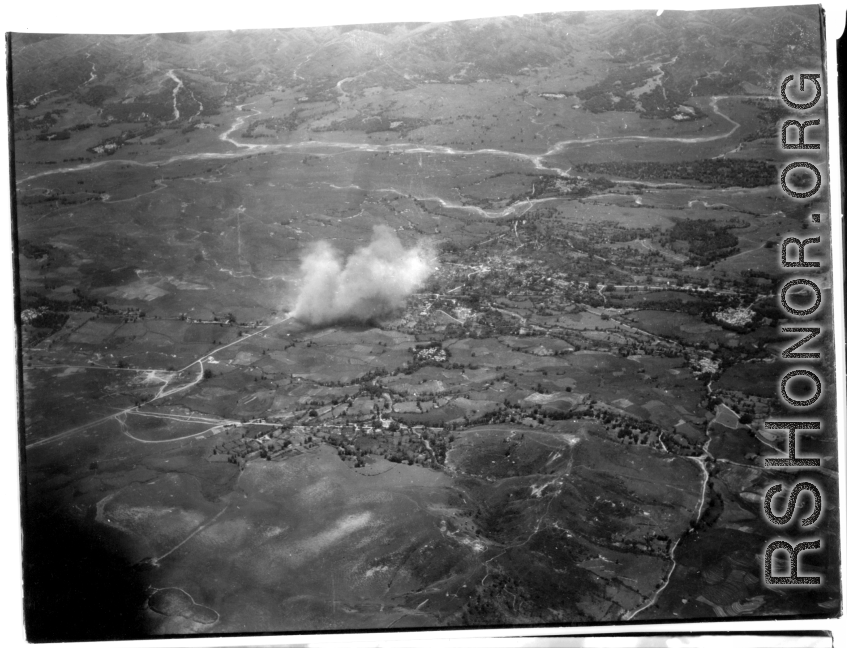 Smokes rises above village, likely in Burma, but possibly in either SW China, or French Indochina during WWII.