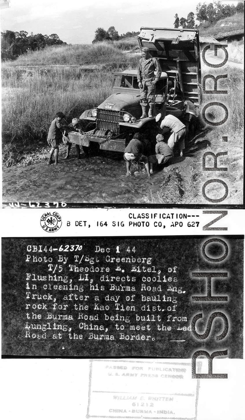 T/5 Theodore E. Eitel directs children in cleaning his Burma Road Engineers truck, after a day of hauling rock for the Kao Tien district of the Burma Road being built from Lungling, China, to meet the Ledo Road at the Burma border.  Yunnan Province on December 1, 1944.   Photo by T/Sgt. Greenberg. B-Detachment, 164th Signal Photographic Company, APO 627.  Passed by William E. Whitten.