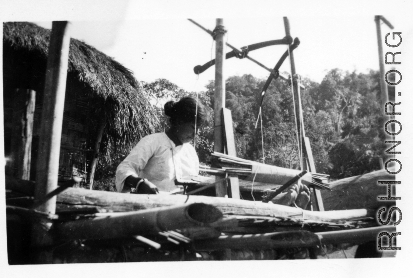 Local people in Burma near the 797th Engineer Forestry Company--A woman weaves on a loom in Burma.  During WWII.
