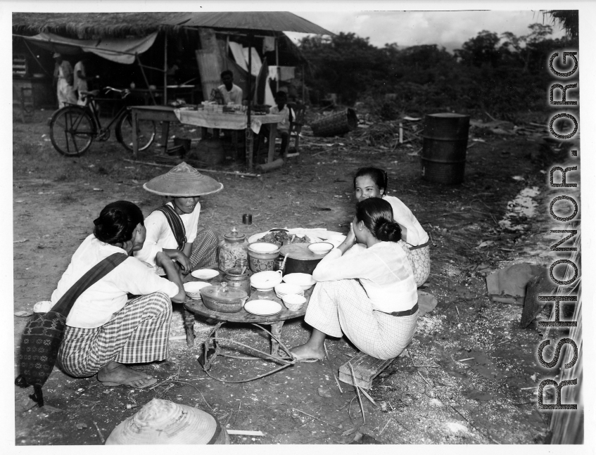 Local people in Burma near the 797th Engineer Forestry Company--Ladies chat over food and drink at a market in Burma.  During WWII.