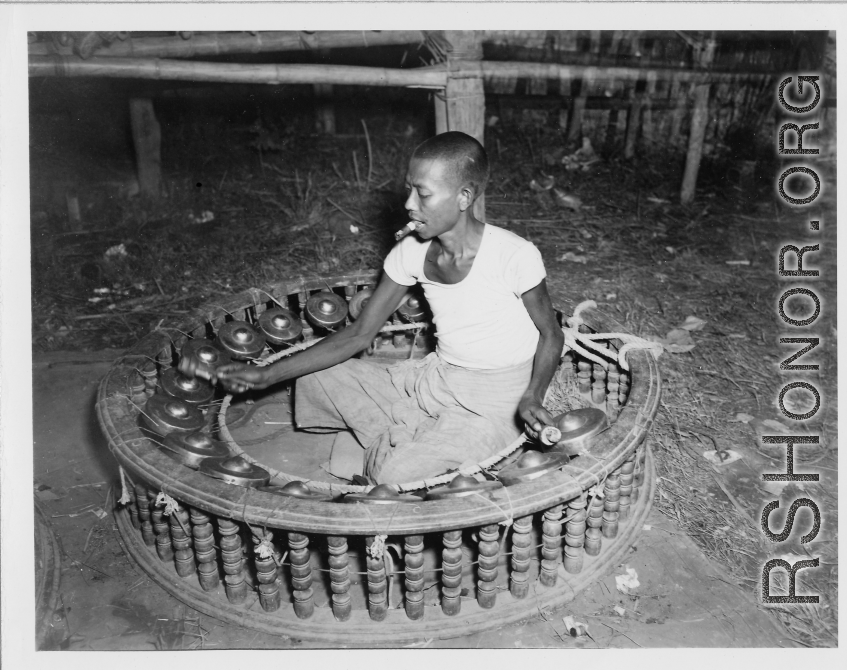 Local people in Burma near the 797th Engineer Forestry Company--Man plays linkwin (cymbals) in Burma.  During WWII.