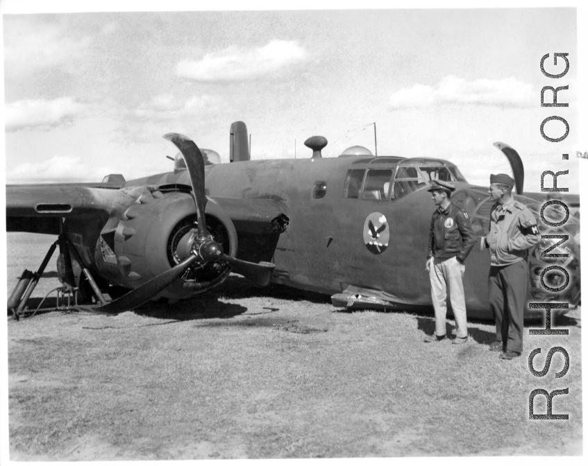 A B-25D of the 22nd Bomb Squadron 'Bombing Eagles' of the 341st Bomb Group rests down on its belly at an airfield in Kunming, China, February 3, 1944. This wrecked B-25 Mitchell should be B-25D-15, #41-30385.   Major Weatherly, the pilot, surveys the crash damage, as does and MP. At the base of the wing is a dark area: damage caused by hitting a ship’s mast during a strafing run (and causing this crash). More information about Major Weatherby and this crash can be seen here.  (Thanks for the research and in
