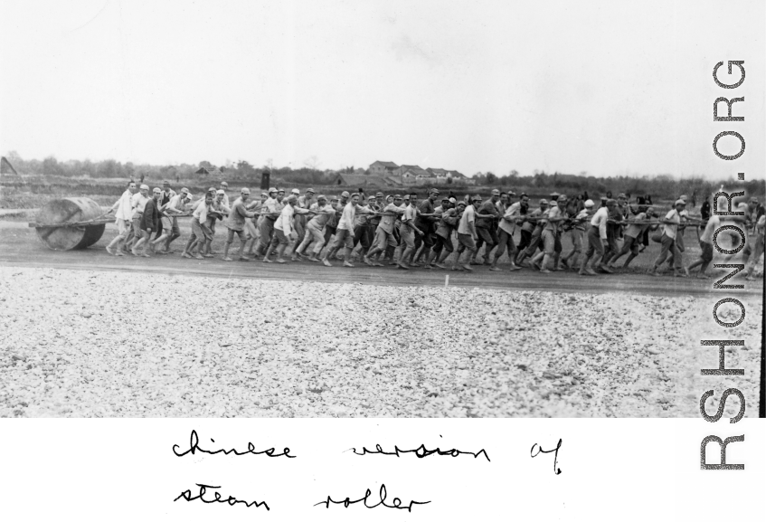 Chinese workers pulling a concrete roller at a field in China, probably in Hunan Province or Guangxi Province. During WWII.