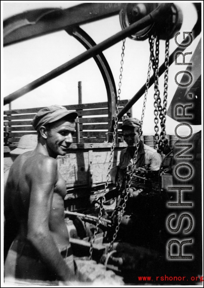 GI repair something at the front of a transport truck, possibly replacing an engine. During WWII in the CBI.