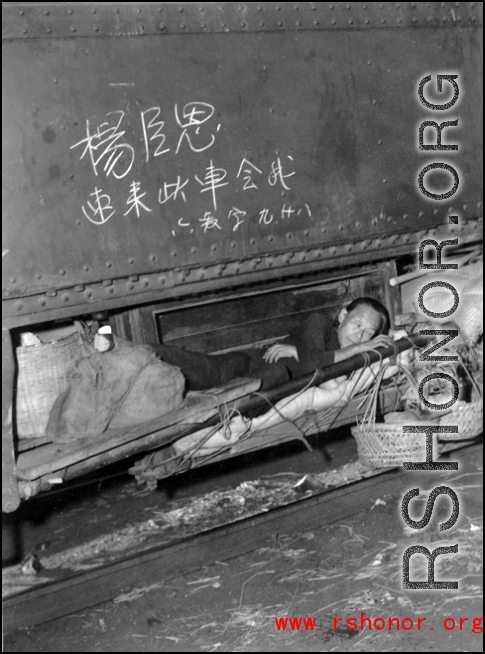 A Chinese refugee stashed away on a precious spot on a train during the evacuation in Guangxi during the fall of 1944. The writing above is a message from someone for another person to meet up on that train car.