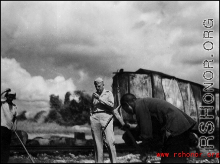 In Liuzhou, Guangxi.  Train in the background burned after Japanese bombing on September 27, 1944.  In the foreground Col. Richard Wise (AGFRTS) takes stock.  According to Hal, Col. Wise was somewhat unconventional, and on at least one occasion made a parachute jump without the proper gear (proper shoes), and was bawled out by Chennault.