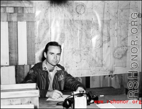 An American soldier with "Flanagan" (花纳根)on his jacket in the CBI. Notice the "491st Bomb Squadron daily status" on the wall behind him. This is a photo of Captain James Flanagan who was the operations officer of the 491st Bomb Squadron. This photo was taken probably at Yangkai Airbase in late 1944. Please see: http://www.usaaf-in-cbi.com/ for additional information. (Thanks to sds) From the collection of Wozniak, combat photographer for the 491st Bomb Squadron, in the CBI.