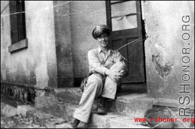An American serviceman, presumably a member of the  27th Troop Carrier Squadron, sits on a step in the CBI during WWII.