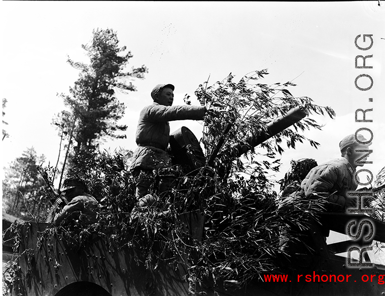 Chinese soldiers with equipment ready and American M3 Scout Car, covered in bamboo branches as camouflage, during exercises in southern China, in Yunnan province.
