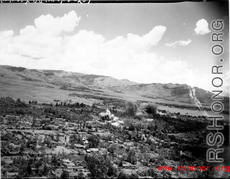 A explosion in Japanese-held Tengchong, probably from a bomb dropped by B-25 Mitchell bombers during battle with Japanese ground forces, flying over Tengchung (Tengchong), near the China-Burma border in far SW China.