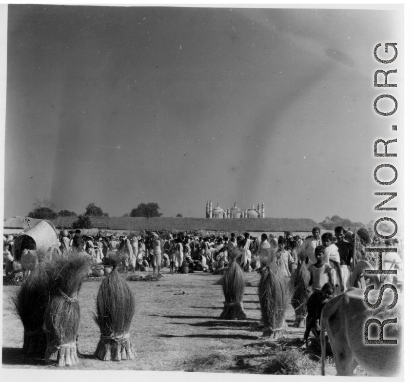 Busy market area with the roof of a temple beyond.  Scenes in India witnessed by American GIs during WWII. For many Americans of that era, with their limited experience traveling, the everyday sights and sounds overseas were new, intriguing, and photo worthy.
