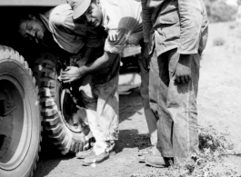 American servicemen--including an African-American serviceman--work on a truck along some road somewhere in the CBI during WWII.  From the collection of Wozniak, combat photographer for the 491st Bomb Squadron, in the CBI.