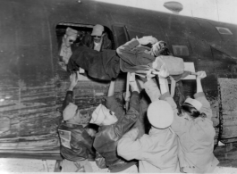 Air evacuation using a B-24 showing loading of a patient through the waist window.