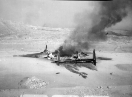 A P-38 fighter destroyed on the ground by a bombing.