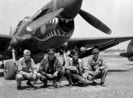 American GIs pose with shark-teeth painted P-40 fighter in the CBI.