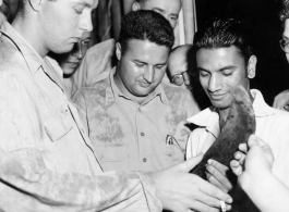 Men examine what is presumably a knife of some kind, in the CBI during WWII.