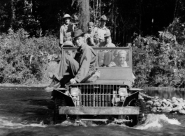 Several GIs cross river in jeep during WWII, in SW China or Burma.