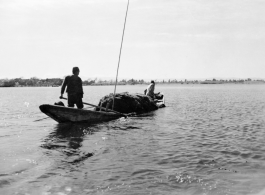 Local people in Yunnan province, China, on a small boat, collecting water grass. During WWII.  From the collection of Eugene T. Wozniak.