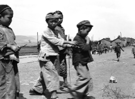 Local boys play beside road in China during WWII, in Yunnan province.