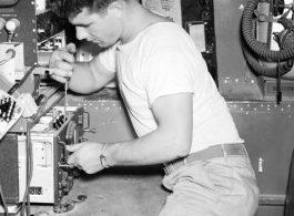 An American serviceman works on electrical equipment in an aircraft in the CBI during WWII.  This image was scanned at high resolution from the original negative and the clarity and detail is exceptional. the white box in the upper right corner is labelled "Desiccated Normal Human Plasma," testifying to the deadly seriousness of the business of these aircraft and their crews.