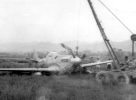 "Here is a picture of Sgt. Miller and Sgt.Blumer's salvage vehicle at work picking up a P-51 that had to make a gear-up landing."