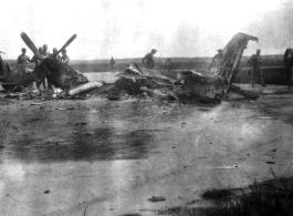 Soldiers look at a burned P-51 fighter in China during WWII.