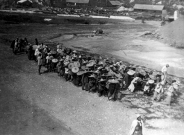 Chinese laborers pull a large concrete roller at an American base in Guangxi, China, during WWII.