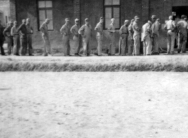 GIs at a base in China line up to go into a building.