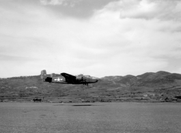 A B-25 Mitchell bomber races by close to the ground, at Yangkai (Yangjie) air strip in Yunnan province, China.