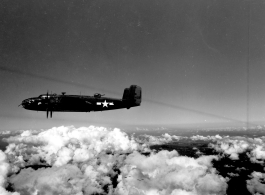 B-25 Mitchell bombers in flight in the CBI, in the area of southern China, Indochina, or Burma. Notice the group further away against clouds at the bottom of the image.