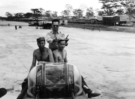 Service crew sits on fuselage of B-25 bomber during WWII.    From the collection of David Firman, 61st Air Service Group.