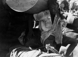 A refugee shields himself from the hot sun with a straw mat in Guangxi province, China, during WWII. Fall 1944.